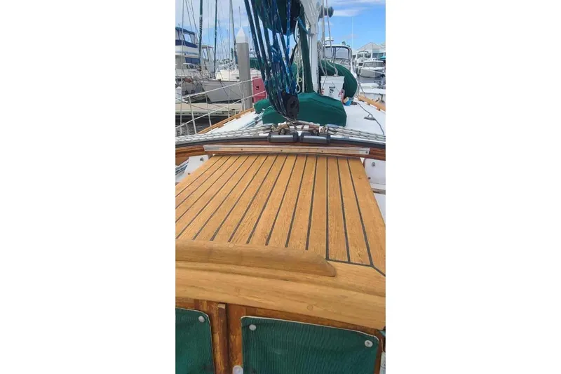 Slide: The Image of 1985 Tayana 37 sailboat deck with wooden finish in marina setting. - 6