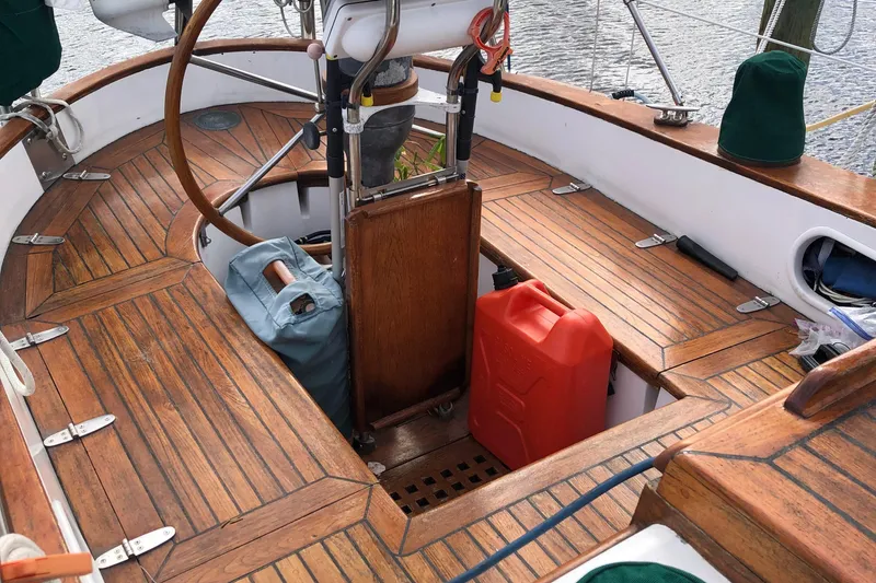 Slide: The Image of 1985 Tayana 37 sailboat cockpit with wooden deck and steering wheel. - 7