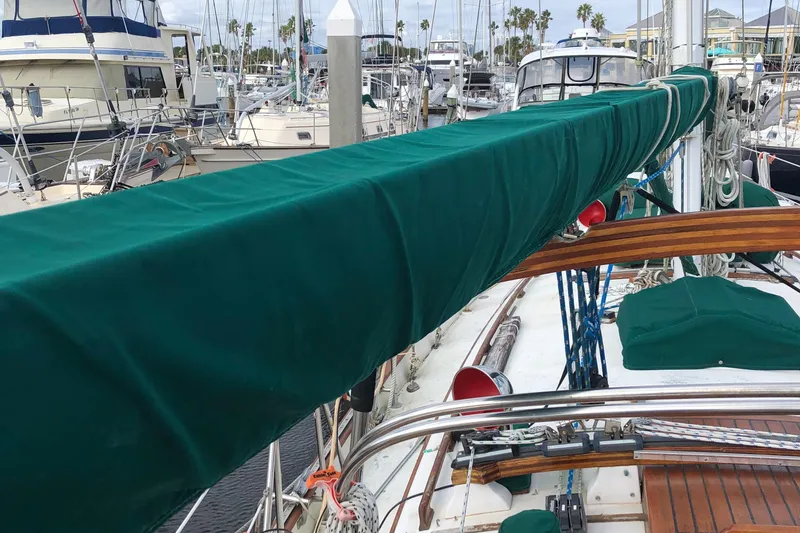 Slide: The Image of 1985 Tayana 37 sailboat with green sail cover docked at marina. - 9
