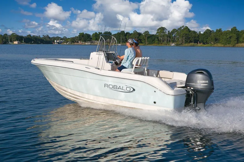 Slide: The Image of 2024 Robalo R180 Center Console boat cruising on a lake. - 14