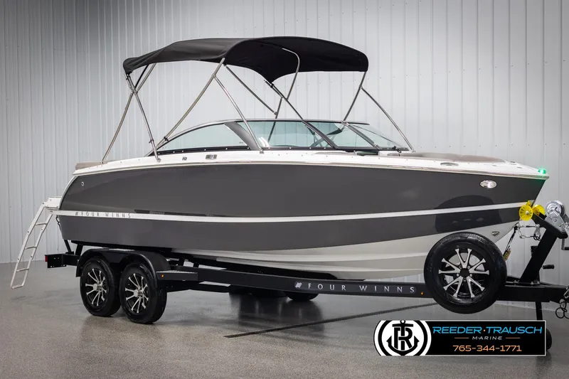 Slide: The Image of 2025 Four Winns H2 boat on trailer, black canopy, displayed indoors. - 3
