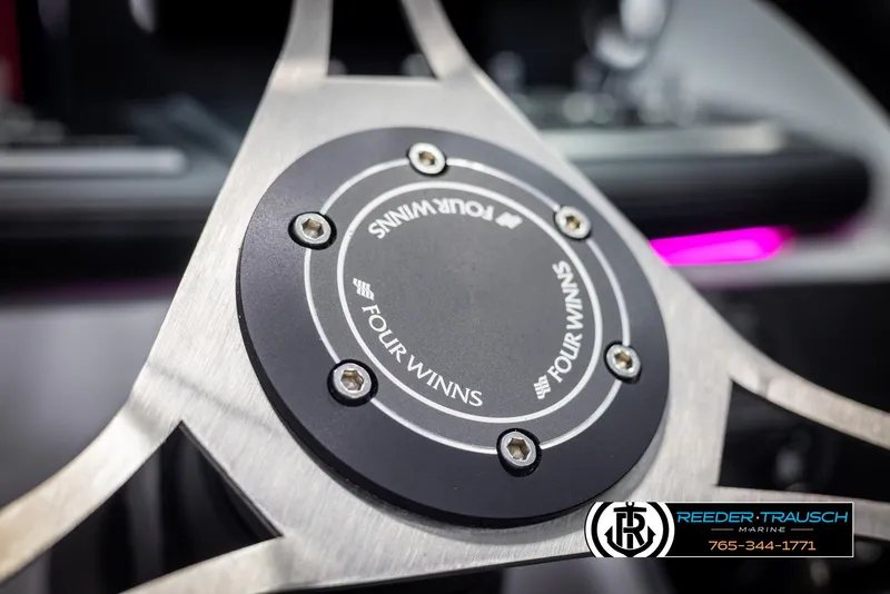 Slide: The Image of Close-up of 2025 Four Winns H2 steering wheel with logo and Reeder-Trausch Marine branding. - 34