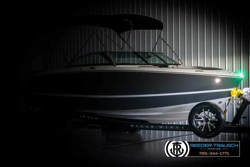 Slide: The Image of 2025 Four Winns H2 boat in a dimly lit showroom, showcasing sleek design and modern features. - 4