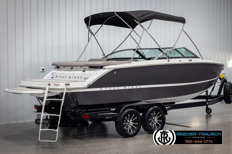 Slide: The Image of 2025 Four Winns H2 boat with canopy on trailer in showroom. - 6