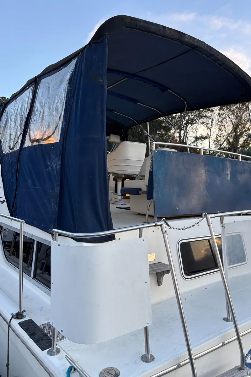 Slide: The Image of 1986 Chris-Craft 381 Catalina boat with blue canopy and upper deck view. - 10