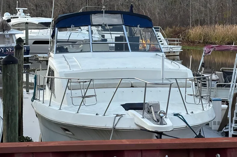 Slide: The Image of 1986 Chris-Craft 381 Catalina docked in a marina, surrounded by other boats. - 15