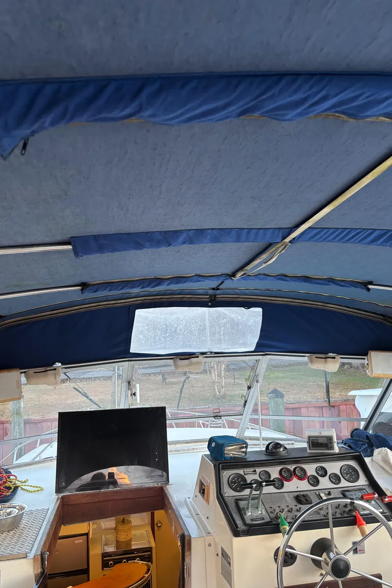 Slide: The Image of 1986 Chris-Craft 381 Catalina boat interior with blue canopy and control panel. - 18