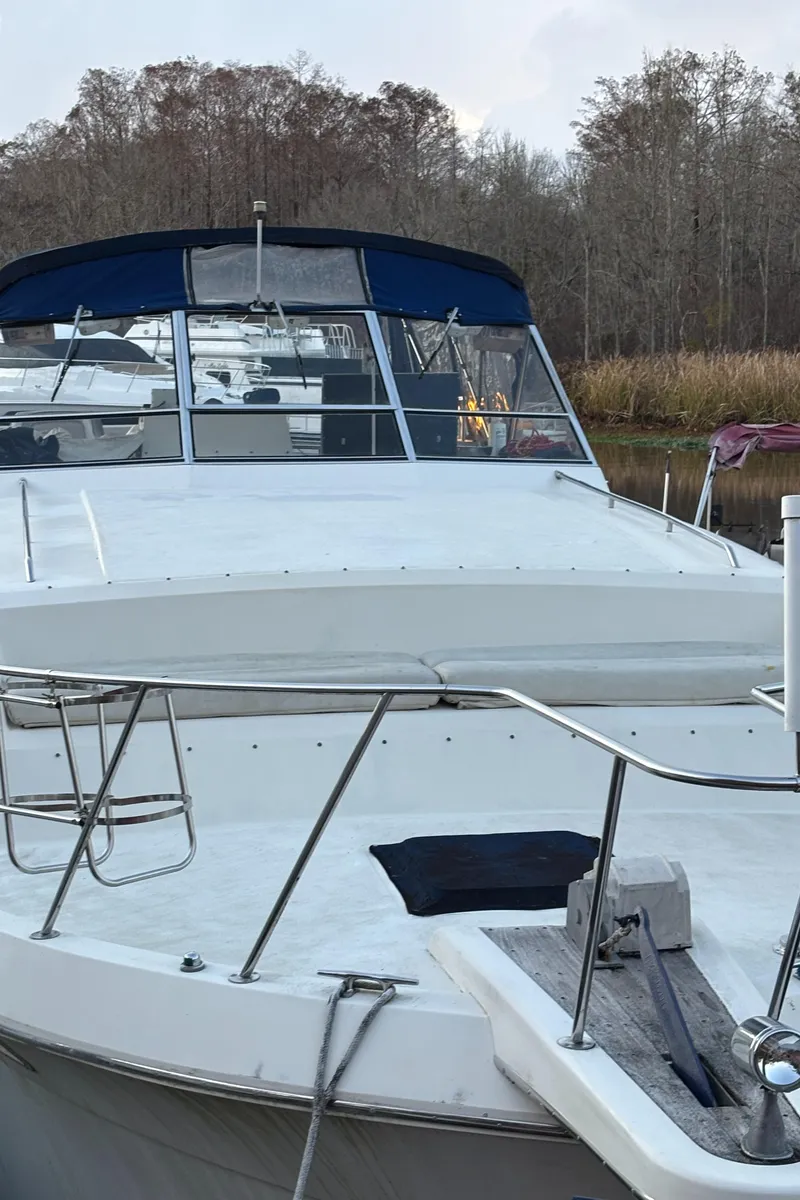 Slide: The Image of 1986 Chris-Craft 381 Catalina yacht docked near wooded shoreline. - 2
