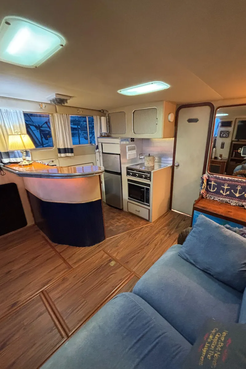 Slide: The Image of Interior of 1986 Chris-Craft 381 Catalina yacht with cozy seating and kitchen area. - 30