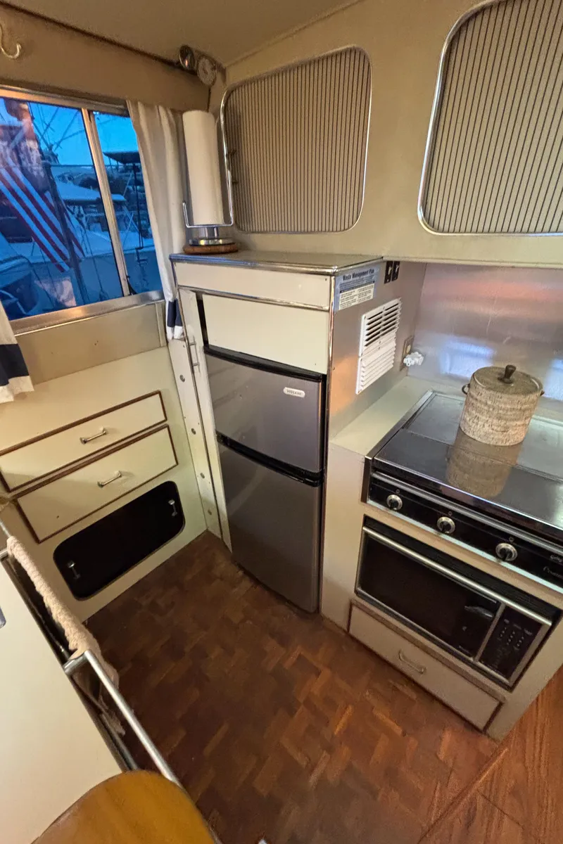 Slide: The Image of 1986 Chris-Craft 381 Catalina kitchen with fridge, oven, and storage. - 32