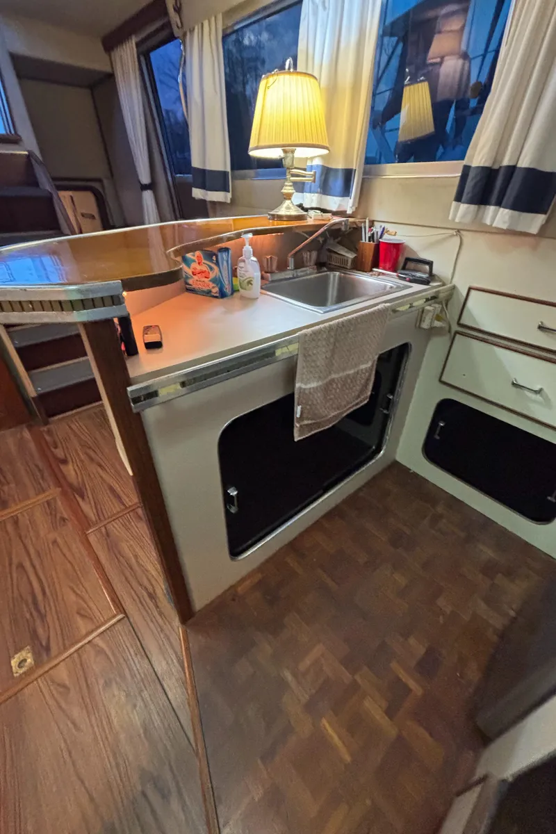 Slide: The Image of 1986 Chris-Craft 381 Catalina kitchen interior with sink, lamp, and wooden flooring. - 33