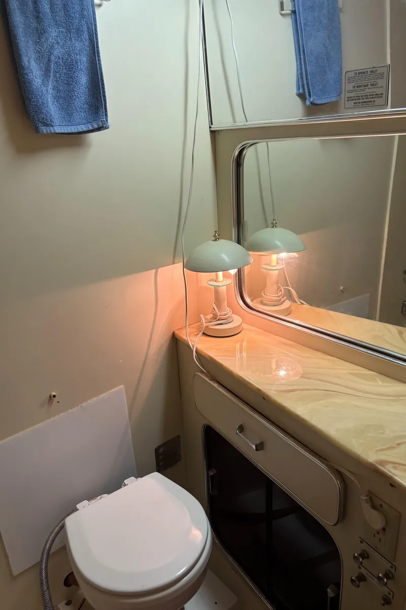 Slide: The Image of 1986 Chris-Craft 381 Catalina bathroom with mirror, lamp, and towel. - 37