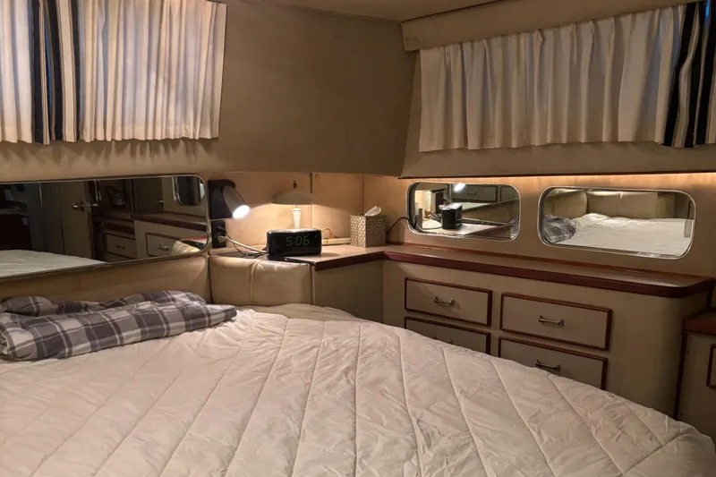 Slide: The Image of Interior of 1986 Chris-Craft 381 Catalina yacht bedroom with cozy bedding and wooden cabinetry. - 40