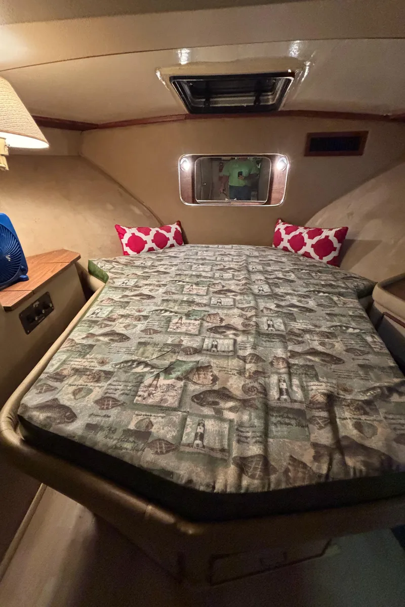 Slide: The Image of Cozy cabin interior of 1986 Chris-Craft 381 Catalina with patterned bedding and red pillows. - 44