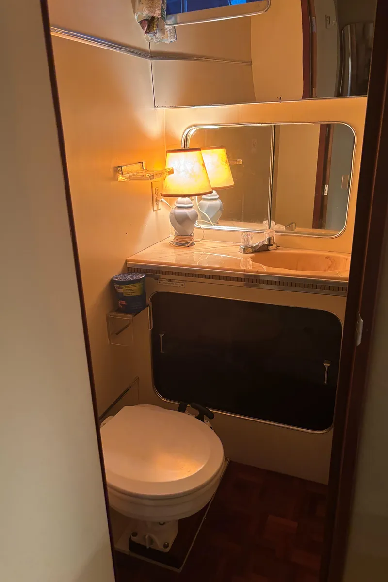 Slide: The Image of 1986 Chris-Craft 381 Catalina bathroom with mirror, lamp, and toilet. - 48