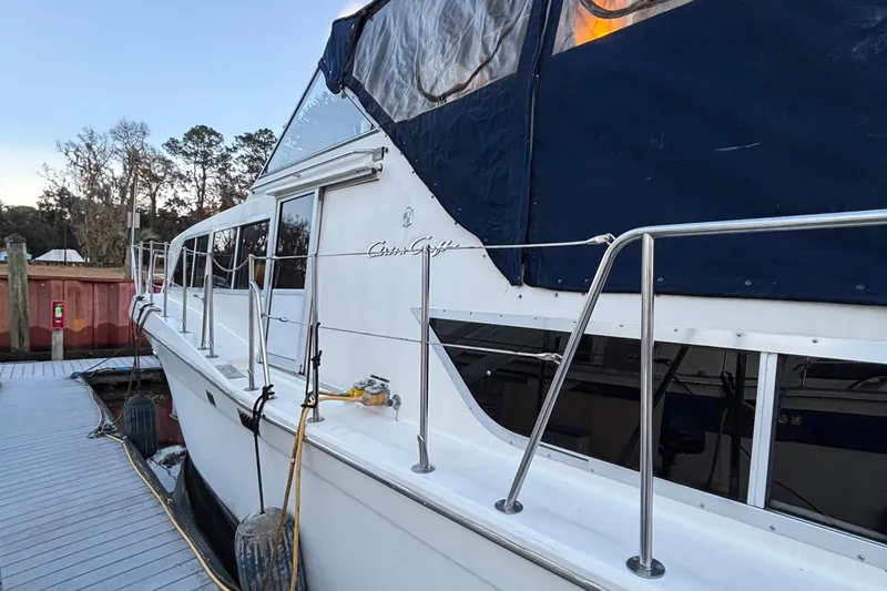Slide: The Image of 1986 Chris-Craft 381 Catalina docked, featuring white hull and blue canopy. - 5