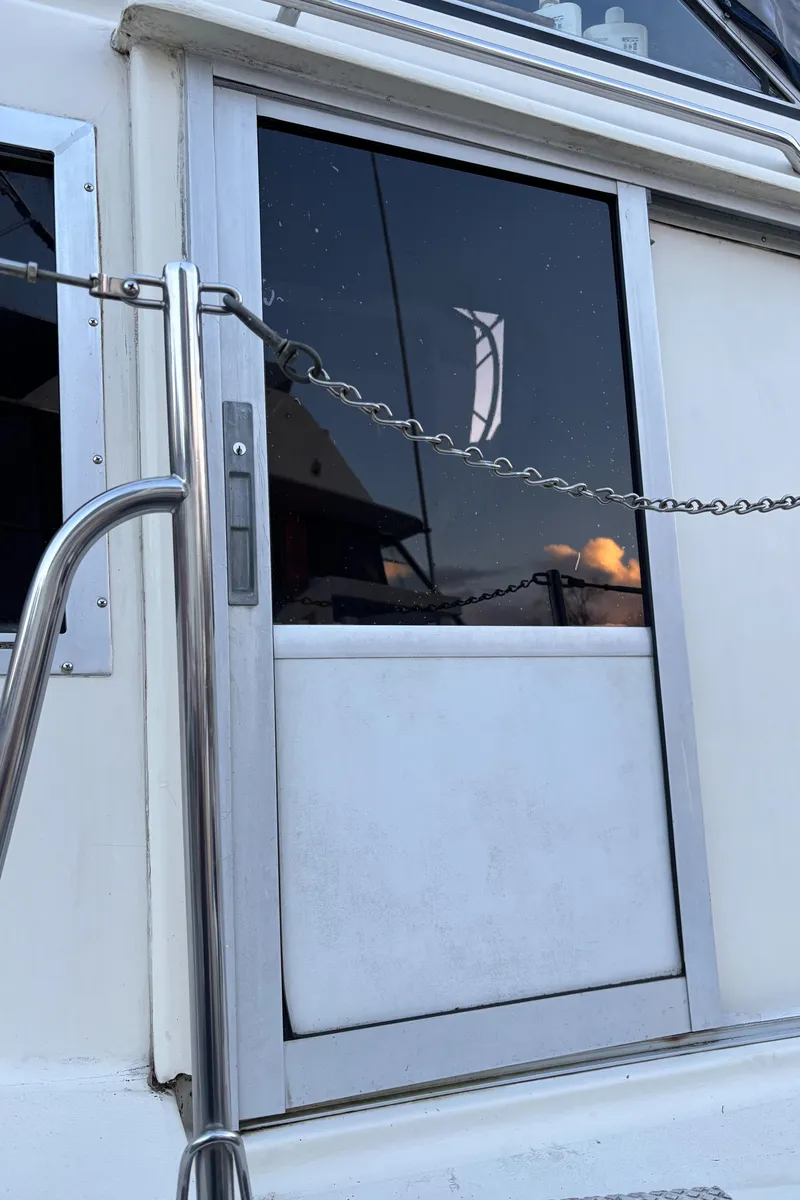 Slide: The Image of 1986 Chris-Craft 381 Catalina boat door with metal railing and chain. - 6