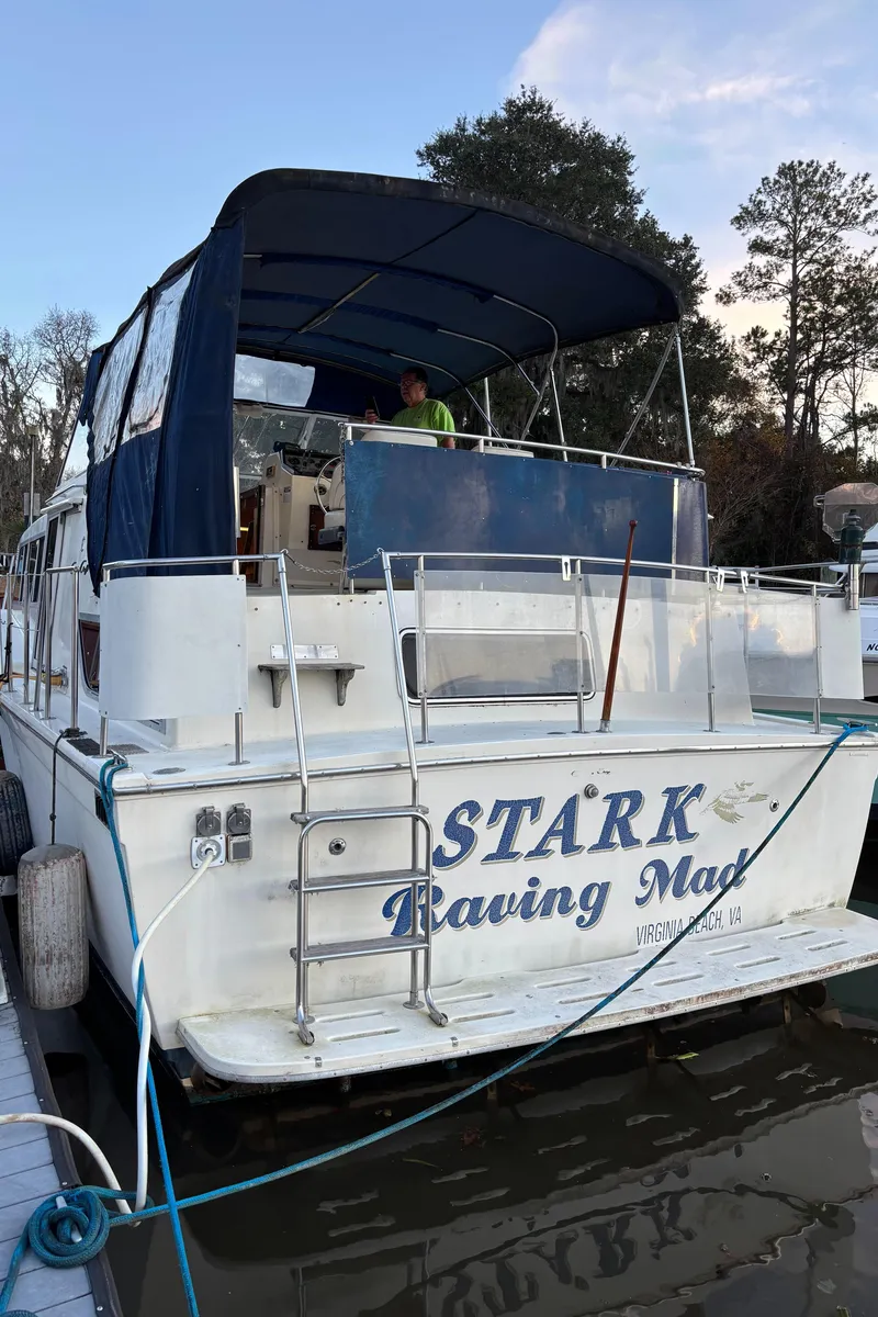 Slide: The Image of 1986 Chris-Craft 381 Catalina boat docked, named "Stark Raving Mad," with blue canopy. - 7
