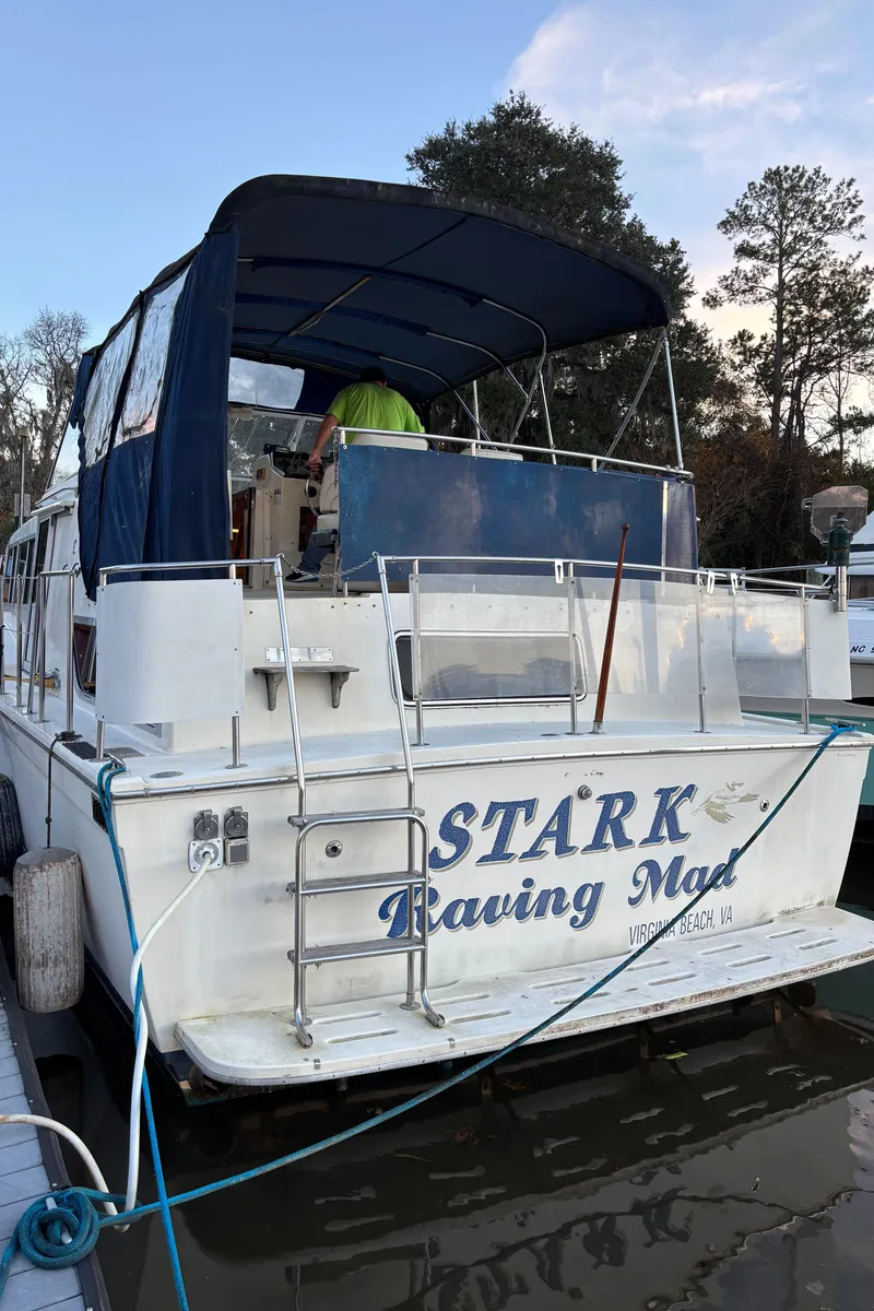 Slide: The Image of 1986 Chris-Craft 381 Catalina boat docked, named "Stark Raving Mad," with blue canopy. - 8