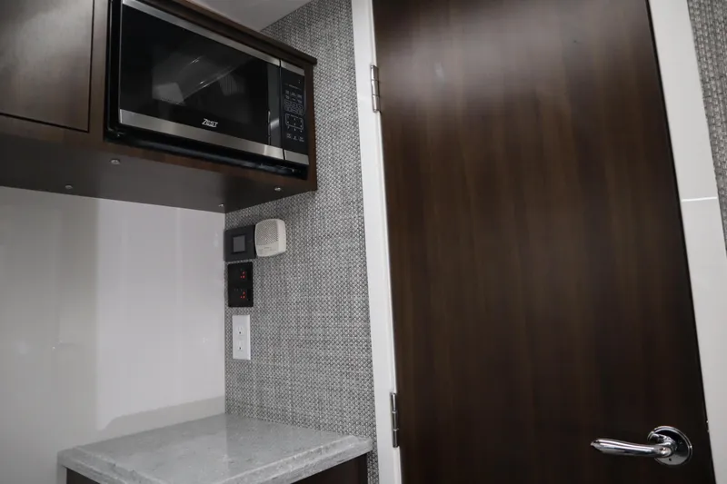 Slide: The Image of Interior of 2025 Everglades 395 Center Console with microwave and modern cabinetry. - 14