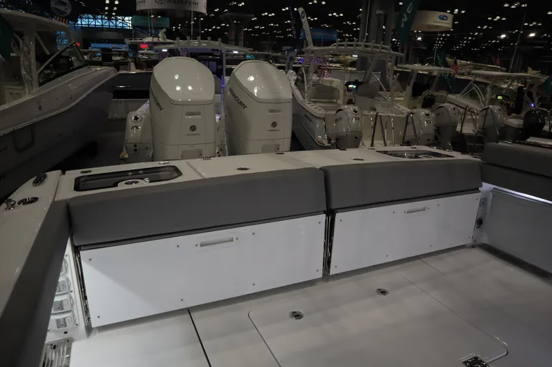 Slide: The Image of 2025 Everglades 395 Center Console boat interior with dual engines at a boat show. - 18