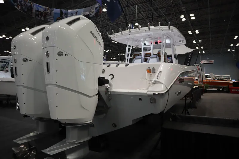 Slide: The Image of 2025 Everglades 395 Center Console boat with dual engines displayed indoors. - 4