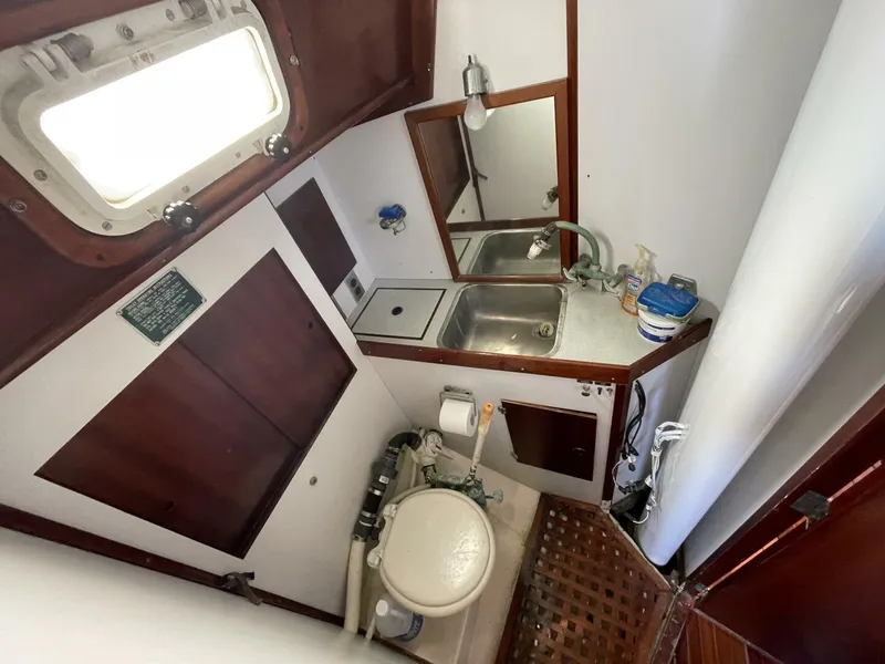 Slide: The Image of 1968 LeComte Northeast 38 yacht bathroom with sink, toilet, and wooden accents. - 18