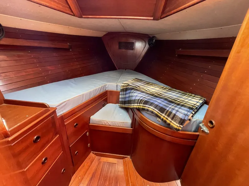 Slide: The Image of Cozy cabin interior of 1968 LeComte Northeast 38 sailboat with wood finish and plaid blanket. - 22