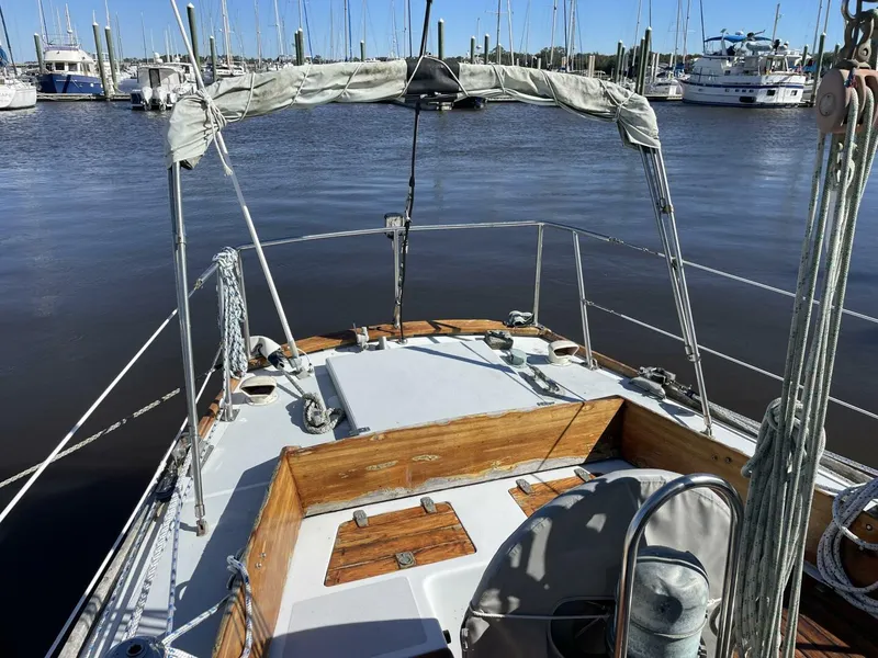 Slide: The Image of 1968 LeComte Northeast 38 sailboat docked in a marina, featuring wooden deck details. - 9