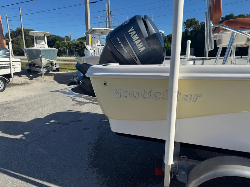 Slide: The Image of 2006 NauticStar 1800 Nautic Bay boat with Yamaha outboard motor in a parking lot. - 2