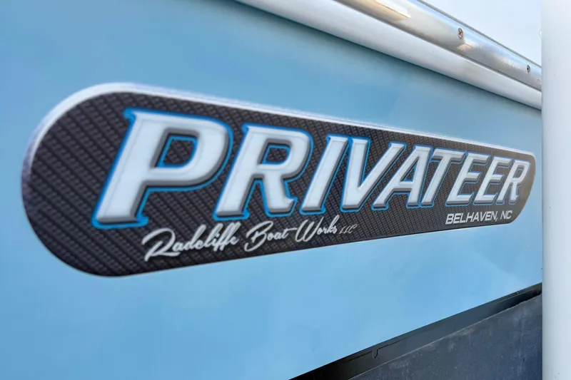 Slide: The Image of Close-up of 2020 Privateer 1800 Retriever boat logo on blue hull. - 7