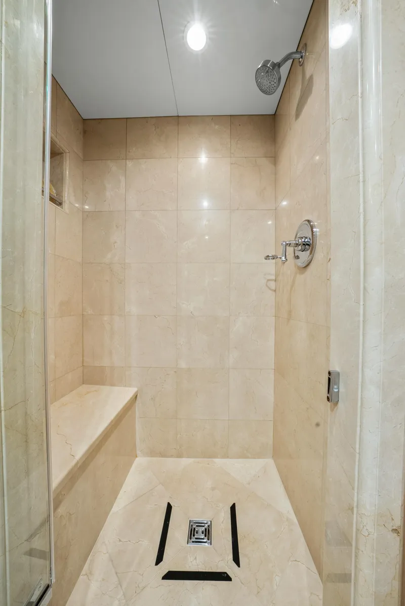 Slide: The Image of Luxurious shower in 2005 Trinity Yachts Tri-Deck, featuring elegant beige tiles and modern fixtures. - 21