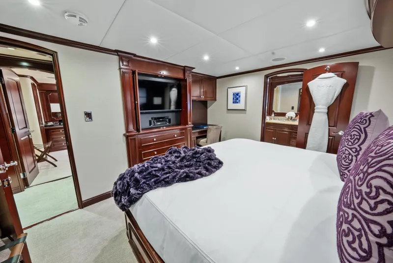 Slide: The Image of Luxurious bedroom interior on 2005 Trinity Yachts Tri-Deck, featuring elegant wood finishes and modern amenities. - 27
