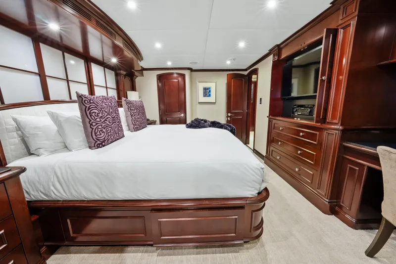 Slide: The Image of Luxurious bedroom interior on 2005 Trinity Yachts Tri-Deck, featuring elegant wood furnishings. - 28