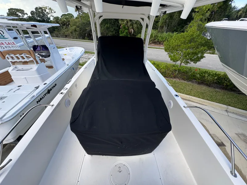 Slide: The Image of 2016 Boston Whaler 270 Dauntless boat with black seat cover, docked beside another boat. - 17