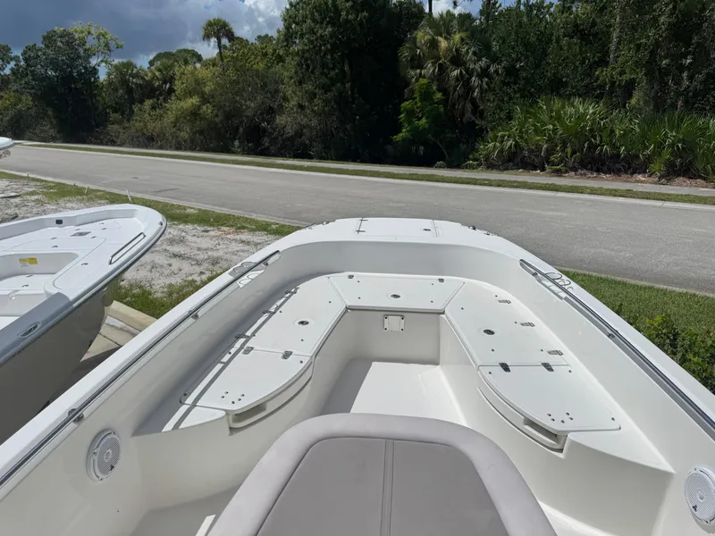 Slide: The Image of 2016 Boston Whaler 270 Dauntless boat, bow view, parked near a road with lush greenery. - 28