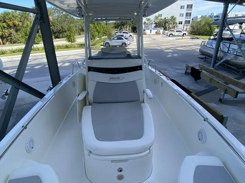 Slide: The Image of 2016 Boston Whaler 270 Dauntless boat interior with seating and console, docked outdoors. - 4