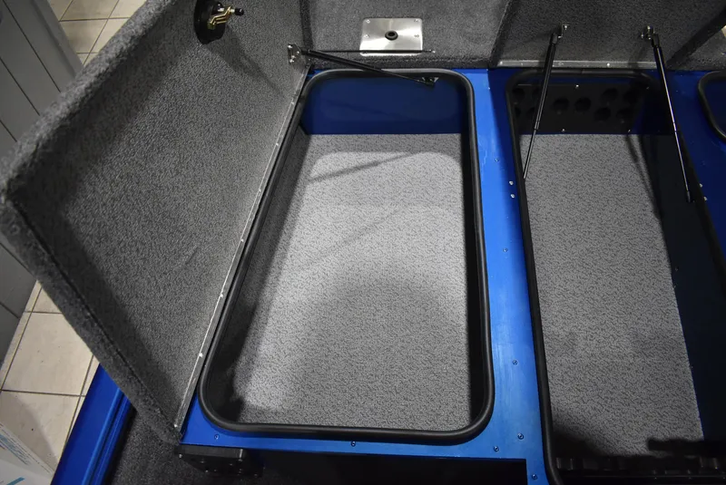 Slide: The Image of Interior storage compartment of 2025 Lund 1775 Renegade SS boat, featuring carpeted finish. - 11