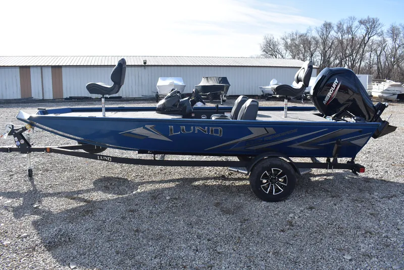 Slide: The Image of 2025 Lund 1775 Renegade SS fishing boat with trailer, blue exterior, parked outdoors. - 4