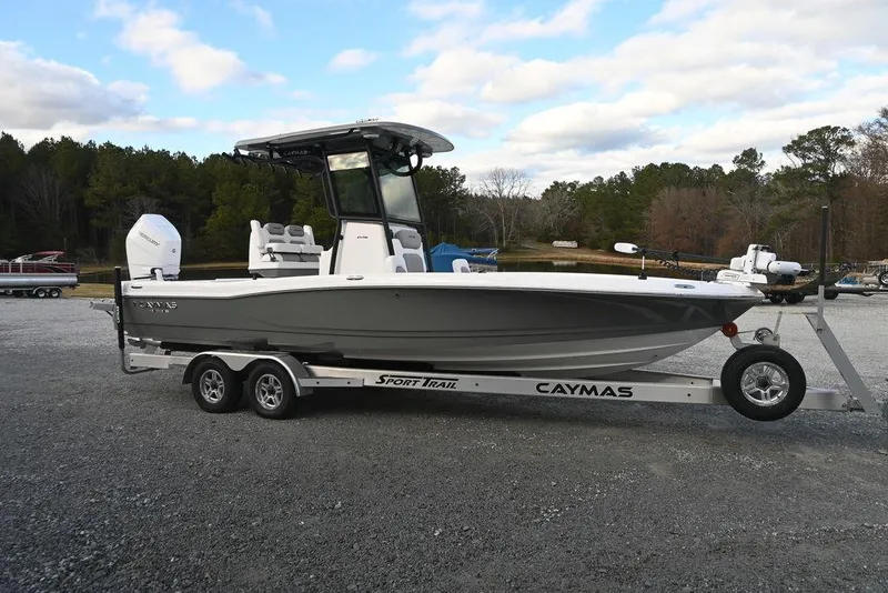 The Image of 2025 Caymas 26 HB boat on trailer, parked outdoors under cloudy sky. - 1
