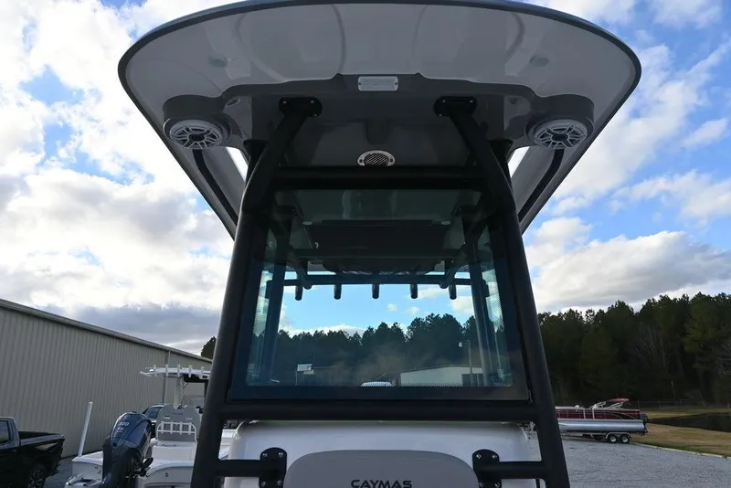 Slide: The Image of 2025 Caymas 26 HB boat with T-top and speakers, under a cloudy sky. - 13