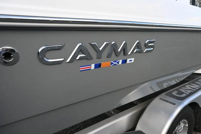 Slide: The Image of 2025 Caymas 26 HB boat logo on gray hull with nautical flags. - 2