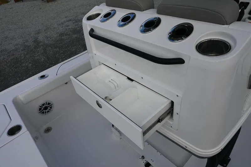 Slide: The Image of 2025 Caymas 26 HB boat with open storage drawer and cup holders. - 30