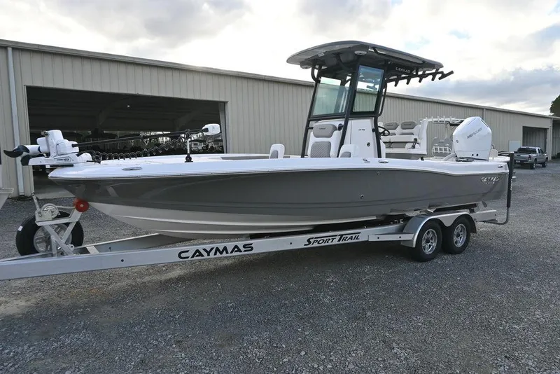 Slide: The Image of 2025 Caymas 26 HB boat on trailer, parked outside a warehouse. - 5
