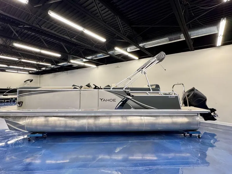 Slide: The Image of 2025 Tahoe LTZ 2385 CRB pontoon boat in showroom, featuring sleek design and modern amenities. - 0