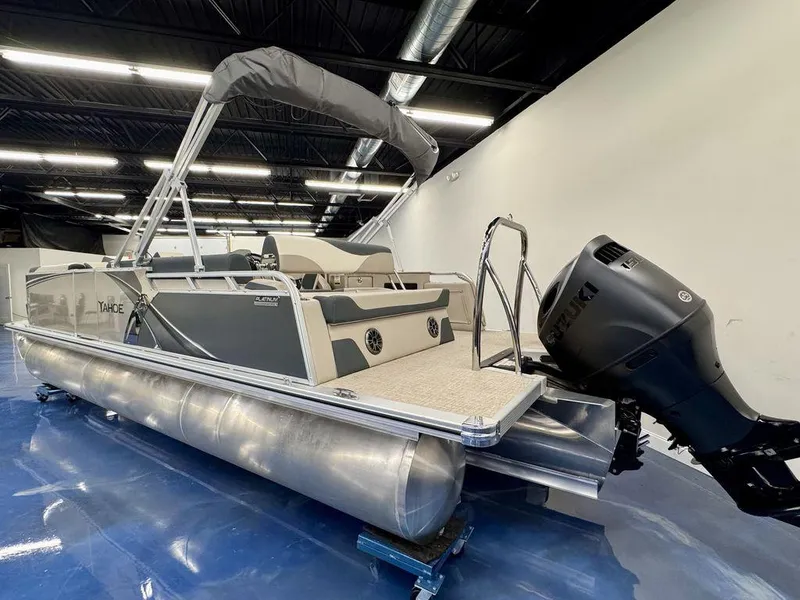 Slide: The Image of 2025 Tahoe LTZ 2385 CRB pontoon boat with Suzuki outboard motor in showroom. - 2
