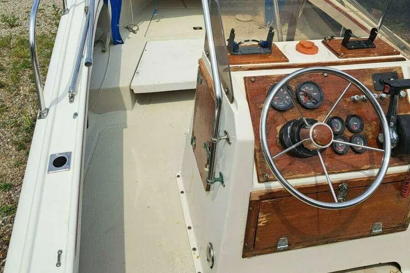 Slide: The Image of 1973 Boston Whaler 21 Outrage boat interior with steering wheel and dashboard controls. - 11
