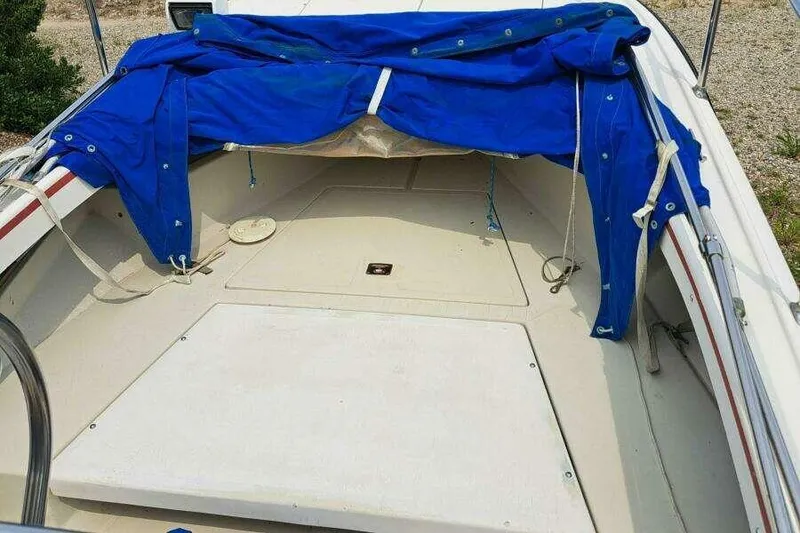 Slide: The Image of 1973 Boston Whaler 21 Outrage boat interior with blue cover and beige deck. - 14