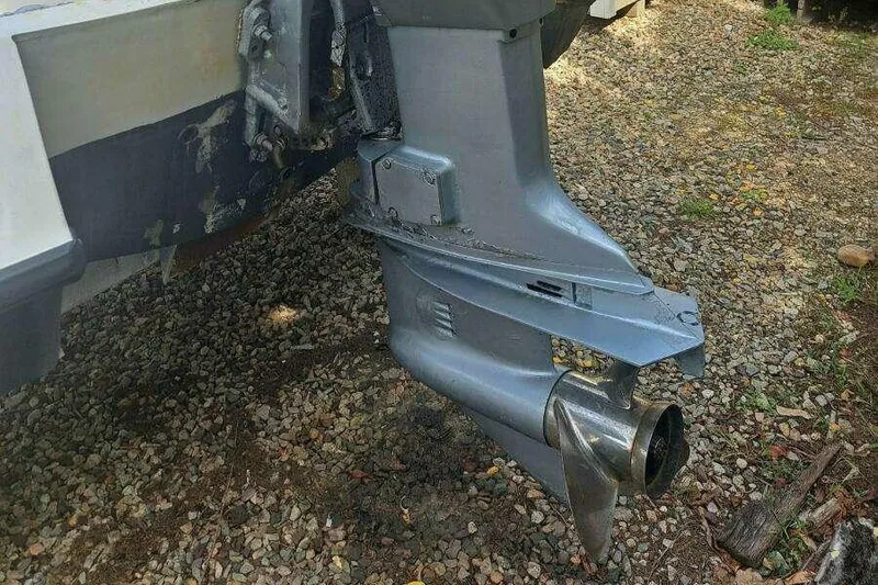 Slide: The Image of 1973 Boston Whaler 21 Outrage boat motor on gravel surface. - 19