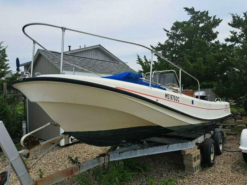 Slide: The Image of 1973 Boston Whaler 21 Outrage boat on trailer, parked outdoors near a shed. - 20